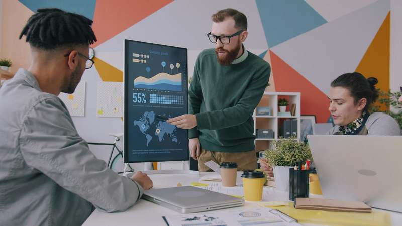 Developer writing neural network code on dual monitors